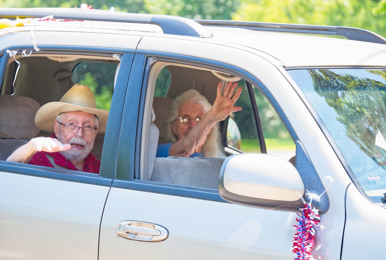 Jim and Lynette Buchanan wave as they drive through Mineola on a “Making Memories” parade put together by friends to let them get out of the house.
